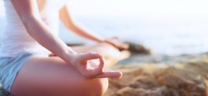 hand of  woman meditating in a yoga pose on beach  